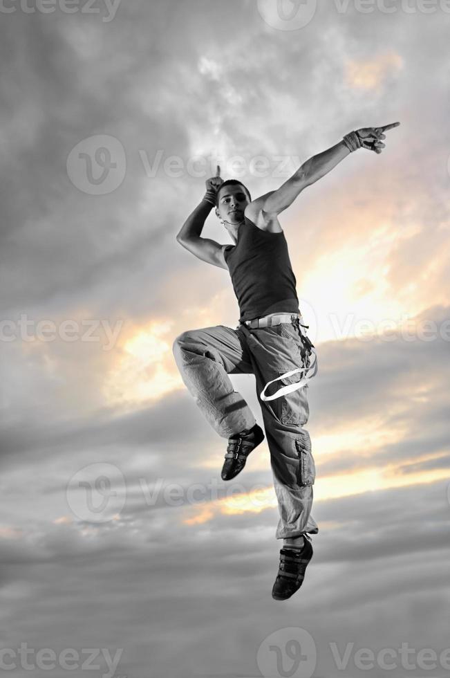 junger Mann tanzt und springt auf das Gebäude foto