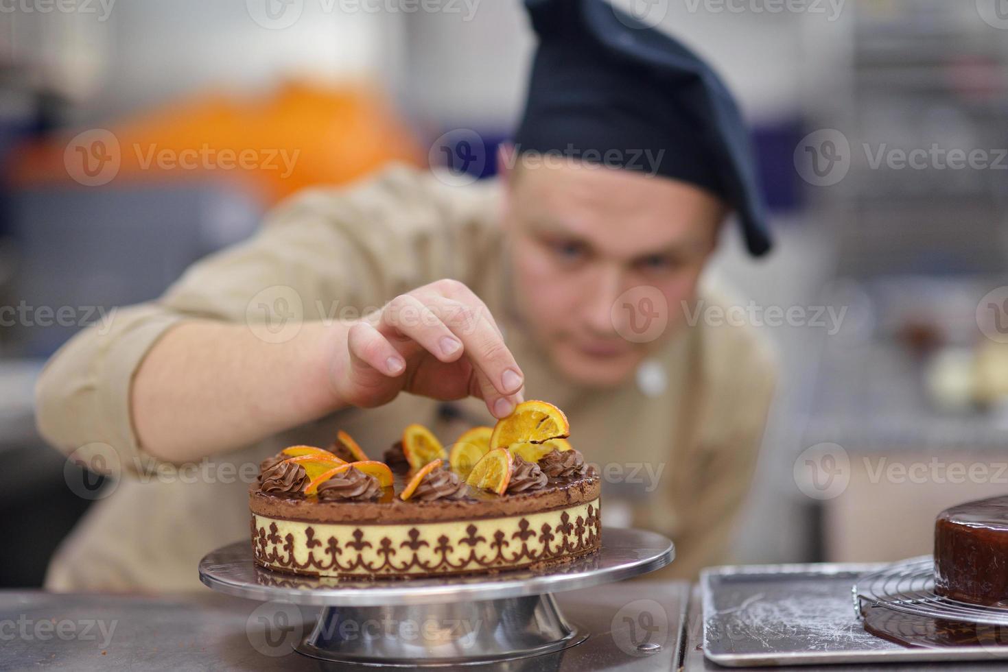 Koch bereitet Wüstenkuchen in der Küche zu foto