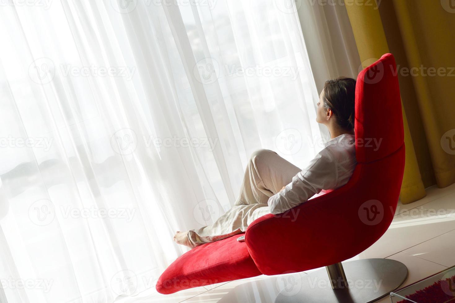 glückliche junge frau entspannt sich zu hause auf dem sofa foto