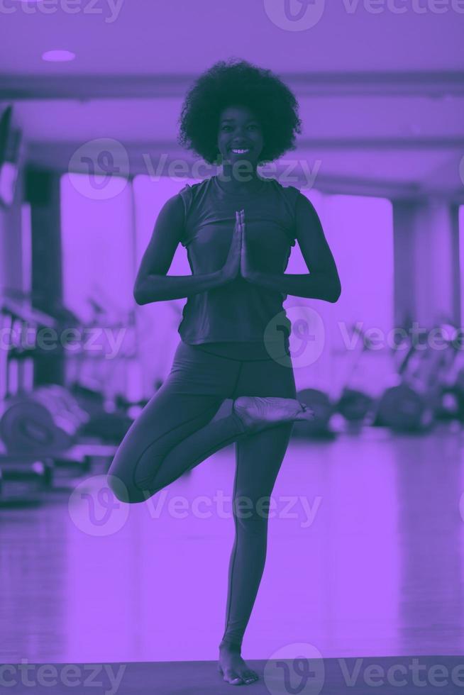 Afroamerikanerin übt Yoga im Fitnessstudio aus foto