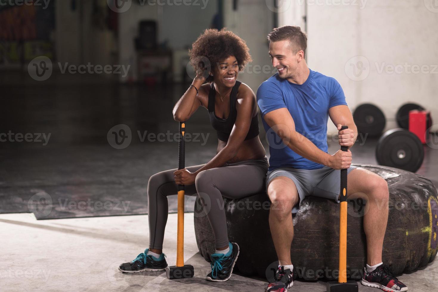 Multiethnisches Paar nach dem Training mit Hammer foto