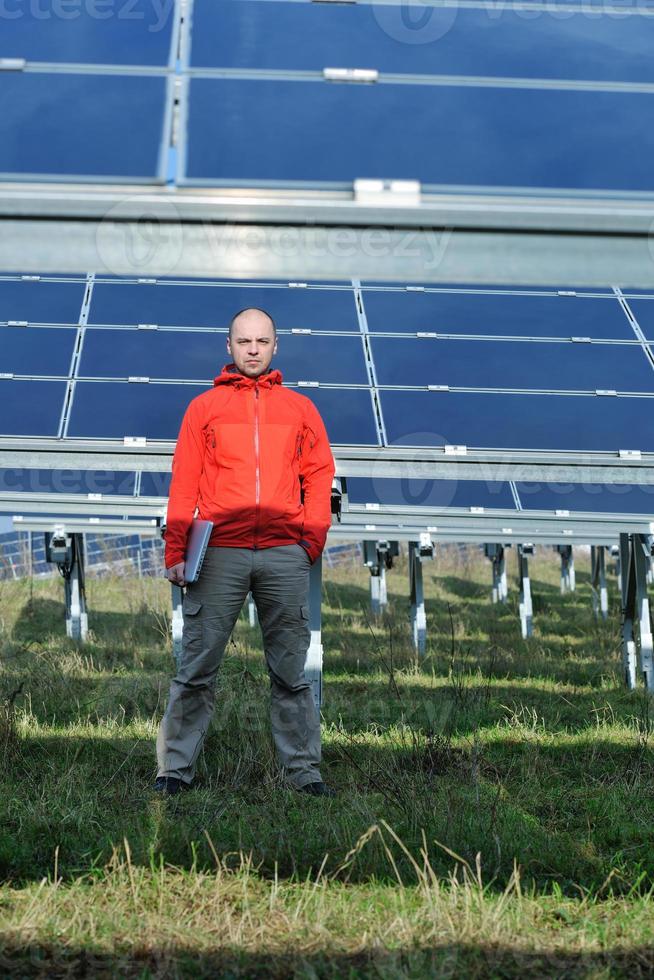 Ingenieur mit Laptop auf dem Feld der Solaranlage foto