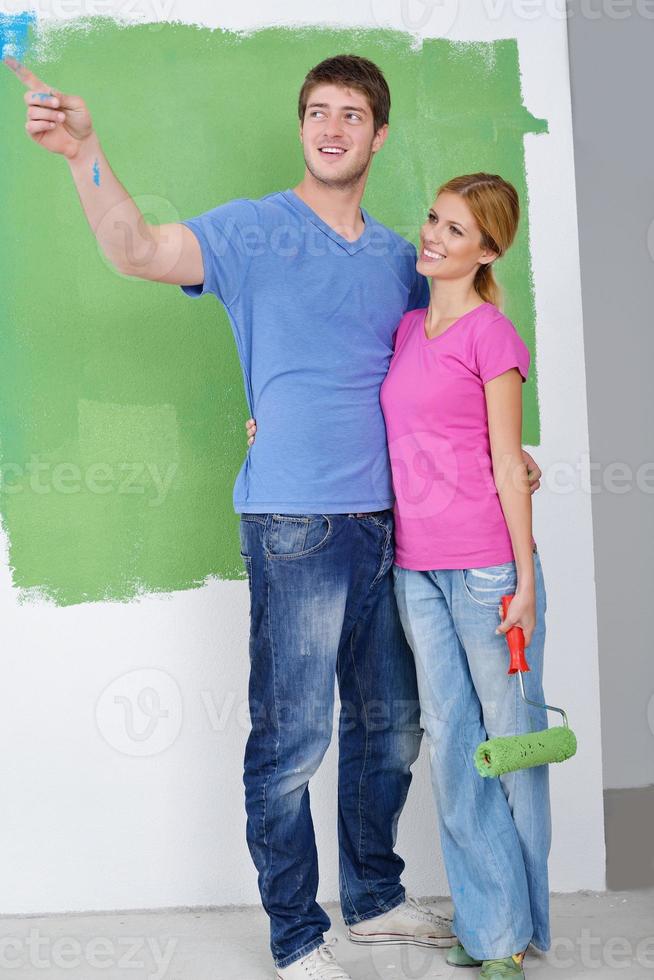 Glückliches Paar malt Wand im neuen Zuhause foto