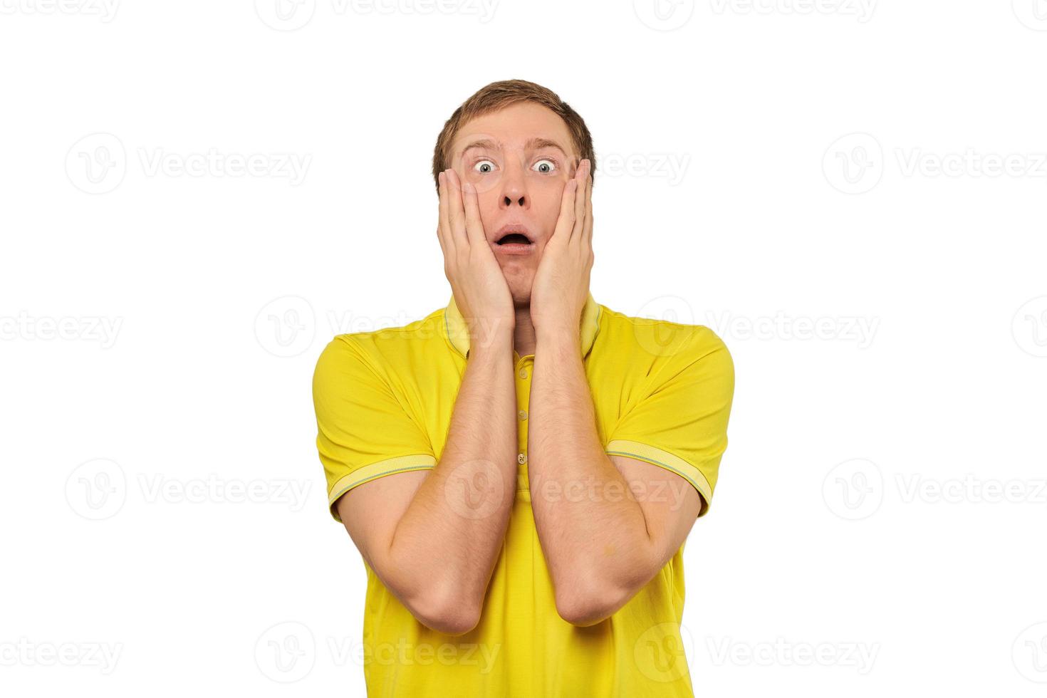 verängstigter junger Mann im gelben T-Shirt, der die Hände über das Gesicht hält, weißer Hintergrund, ängstlich, negativ foto