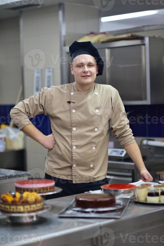 Koch bereitet Wüstenkuchen in der Küche zu foto