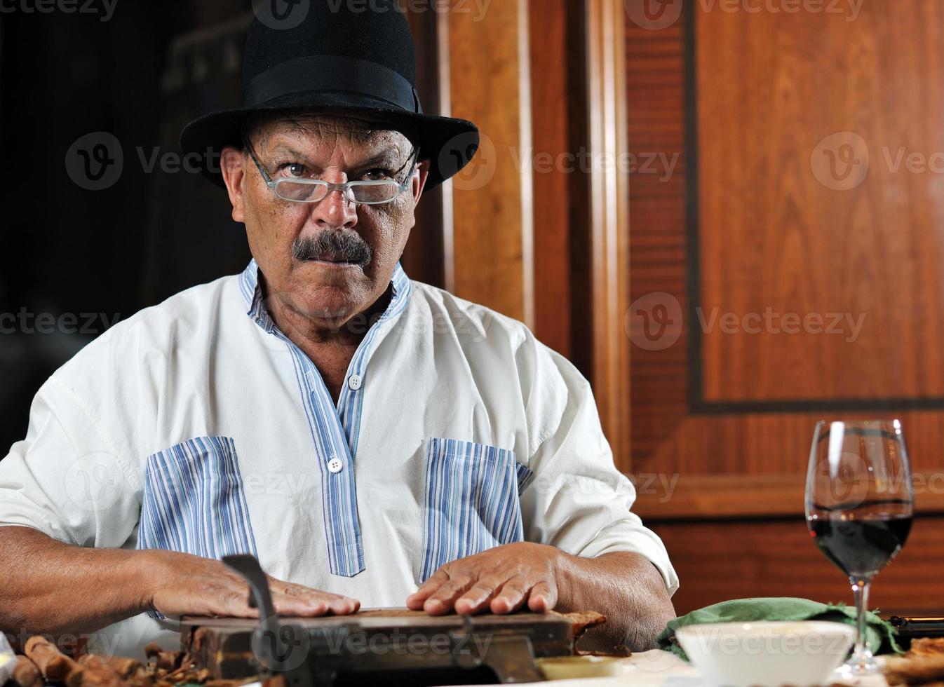 Mann, der handgefertigte kubanische Luxuszigarre herstellt foto