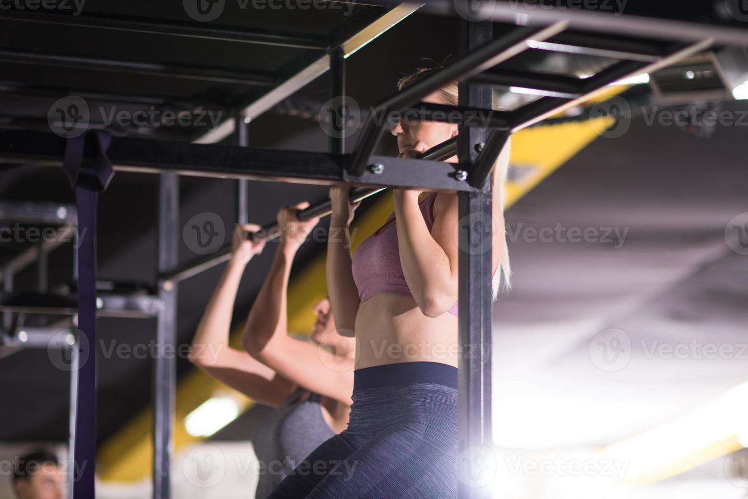 junge Sportler, die Klimmzüge an der horizontalen Stange machen foto