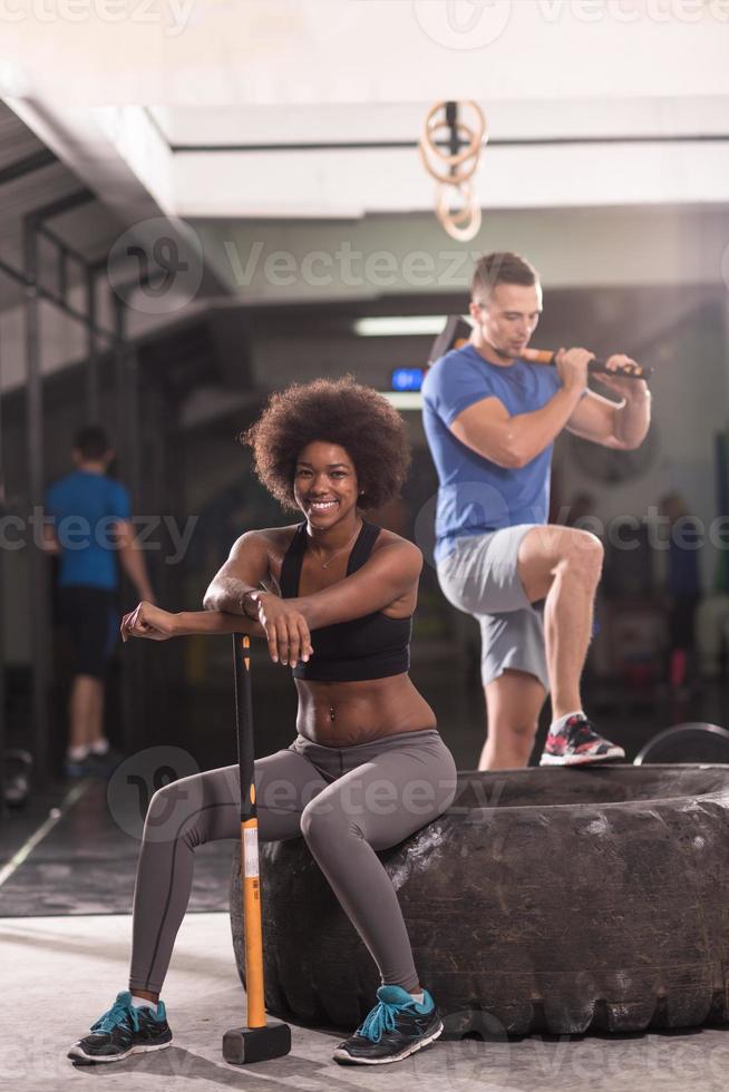 Multiethnisches Paar nach dem Training mit Hammer foto