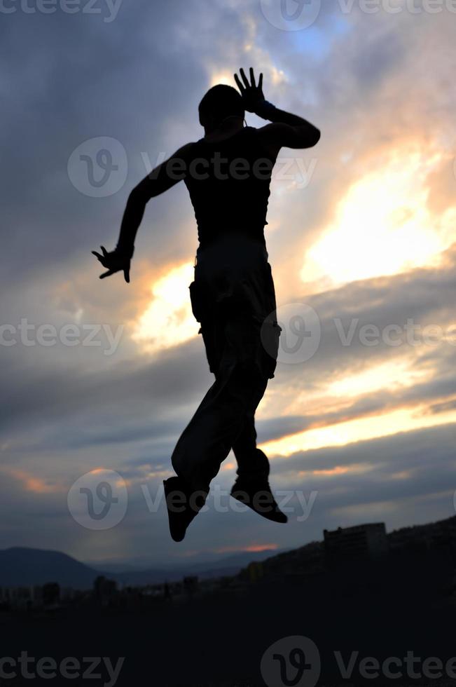 junger Mann tanzt und springt auf das Gebäude foto