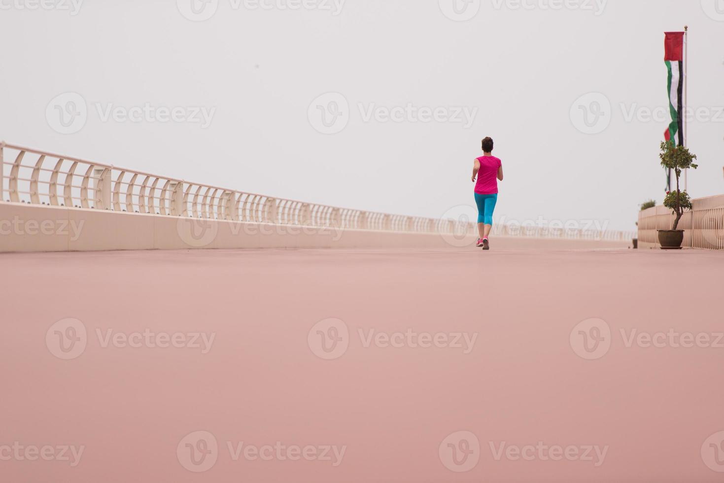 Frau, die damit beschäftigt ist, auf der Promenade zu laufen foto