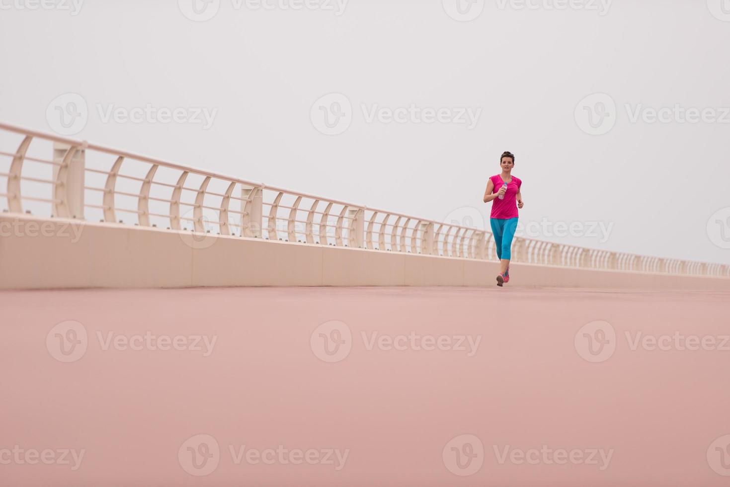 Frau, die damit beschäftigt ist, auf der Promenade zu laufen foto