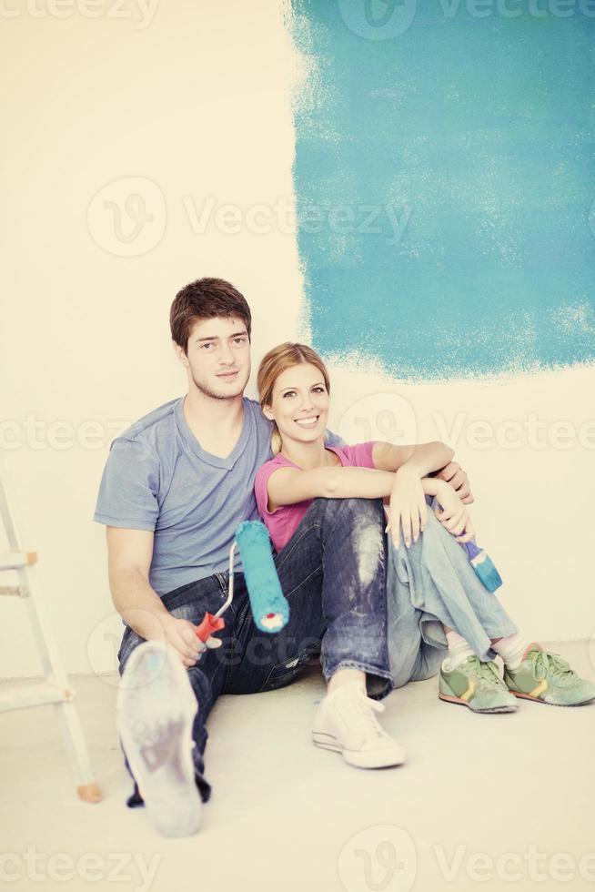 glückliches junges Paar, das sich nach dem Malen im neuen Zuhause entspannt foto