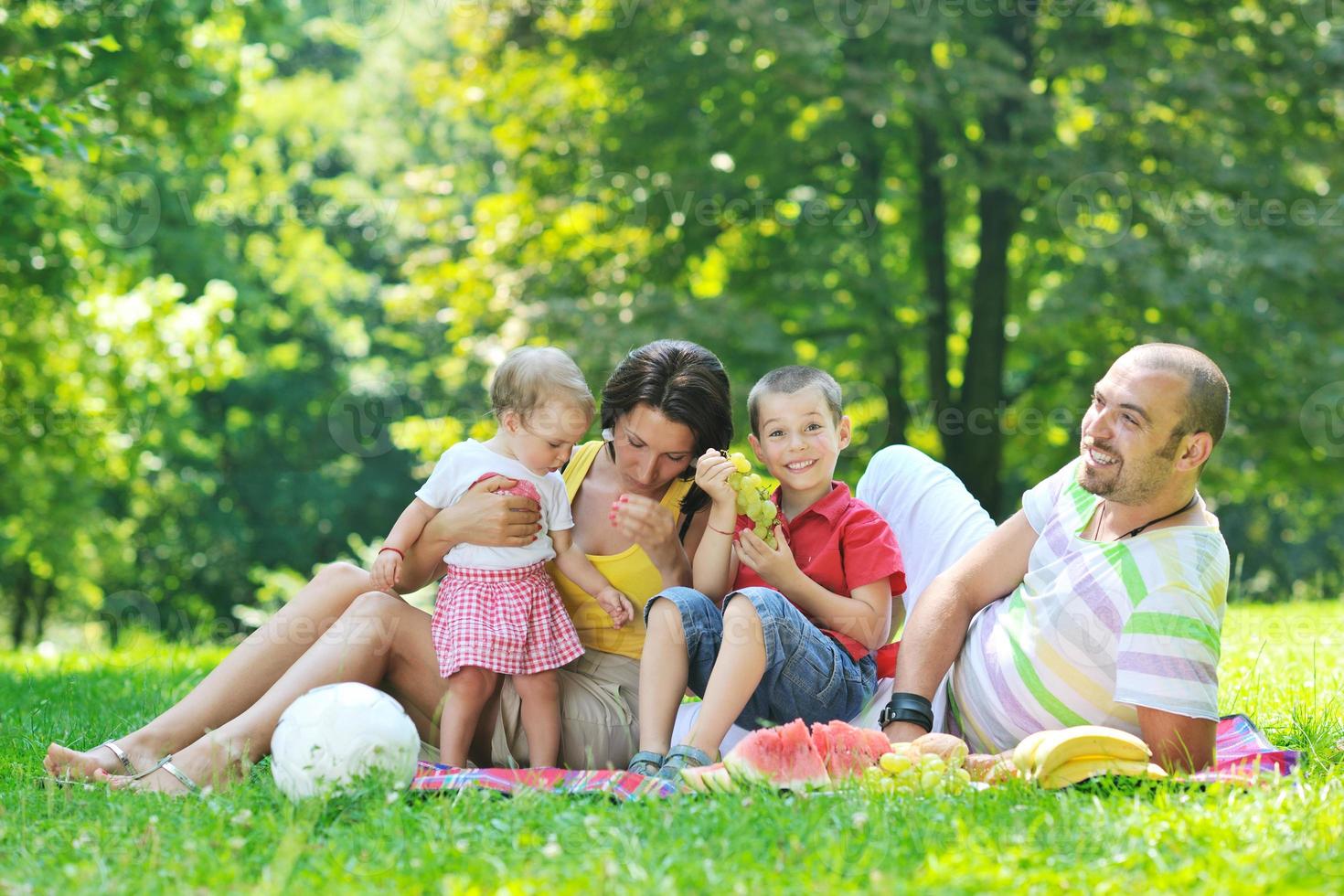 glückliches junges Paar mit ihren Kindern haben Spaß im Park foto