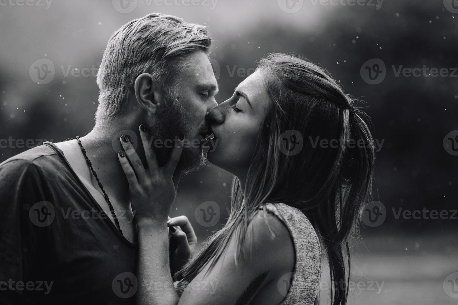 Schönes Paar, das sich im Regen küsst foto
