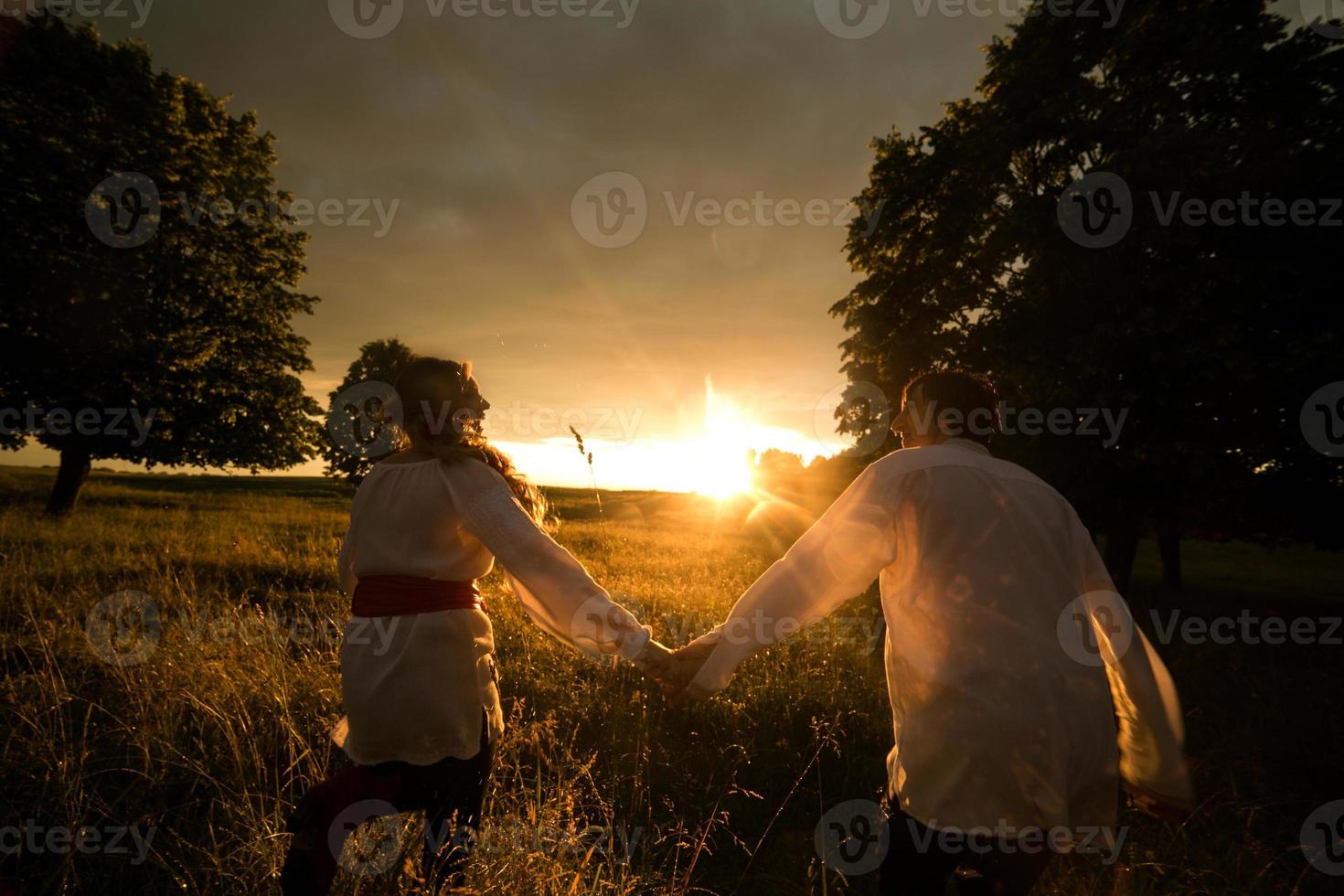 Paar läuft zum Sonnenuntergang foto