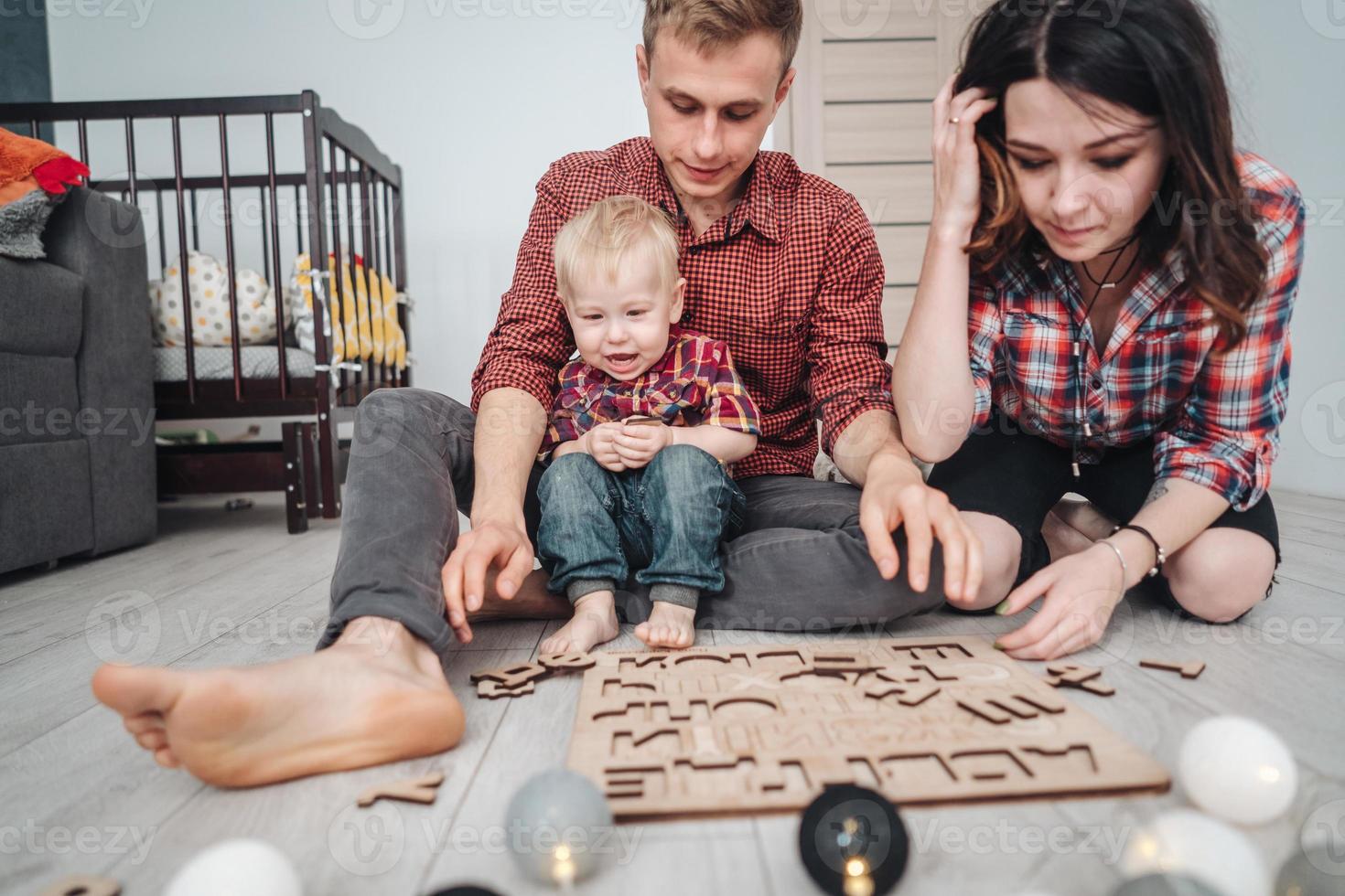 Glückliche Familie spielt zusammen auf dem Boden foto