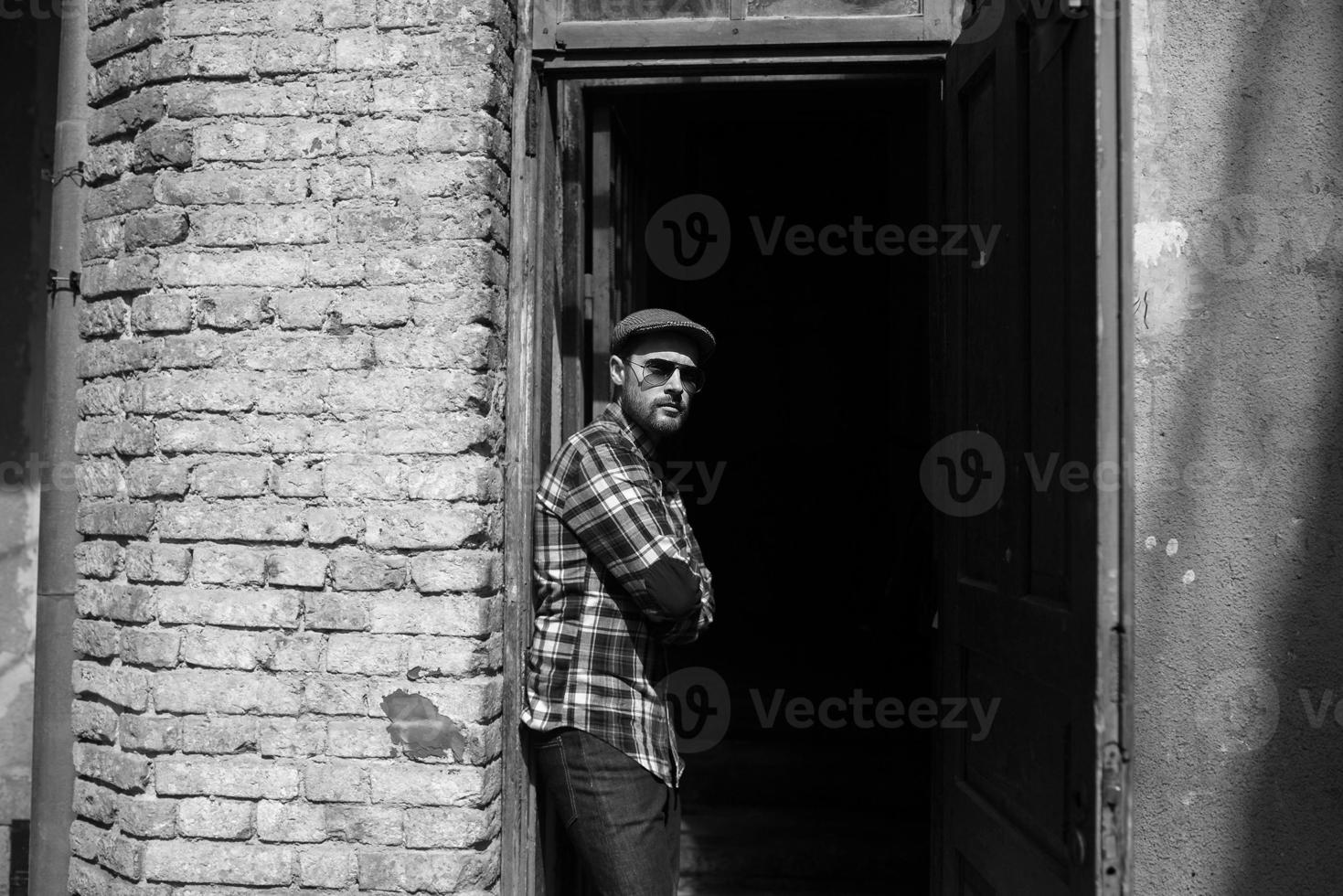 der Mann in den authentischen Stiefeln und Webkantenjeans vor dem Hintergrund der Altstadt foto