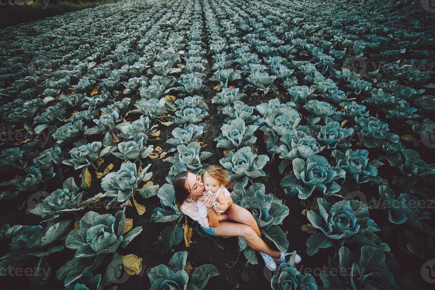 Mutter und Tochter auf dem Feld mit Kohl foto