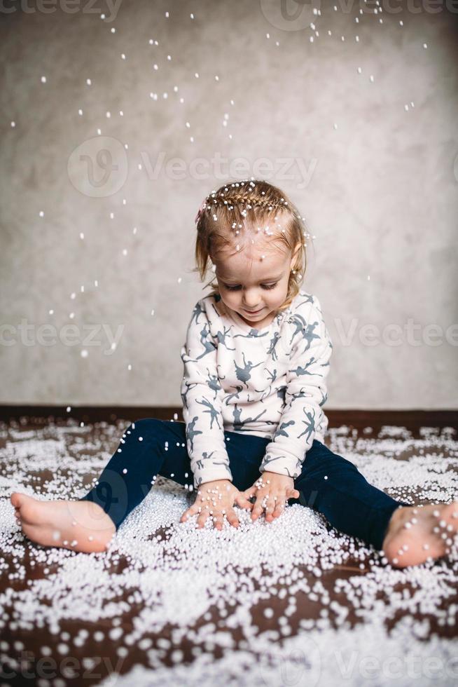 kleines Mädchen spielt mit Schaumstoffbällen foto