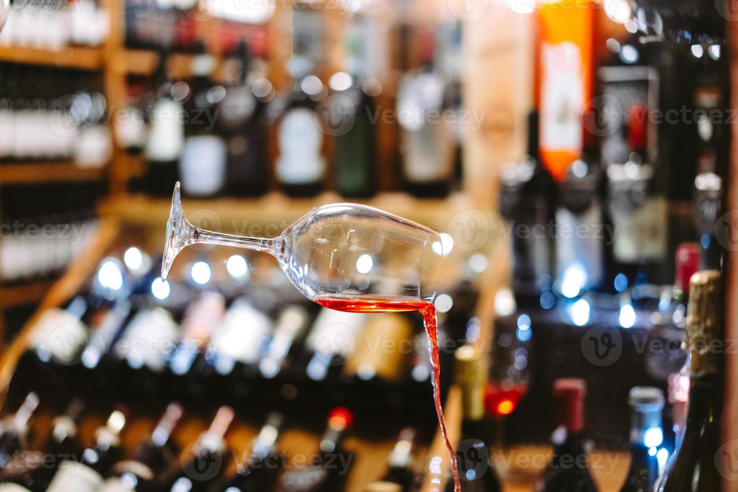 Glas Wein, der mit Verschütten in der Luft fällt foto