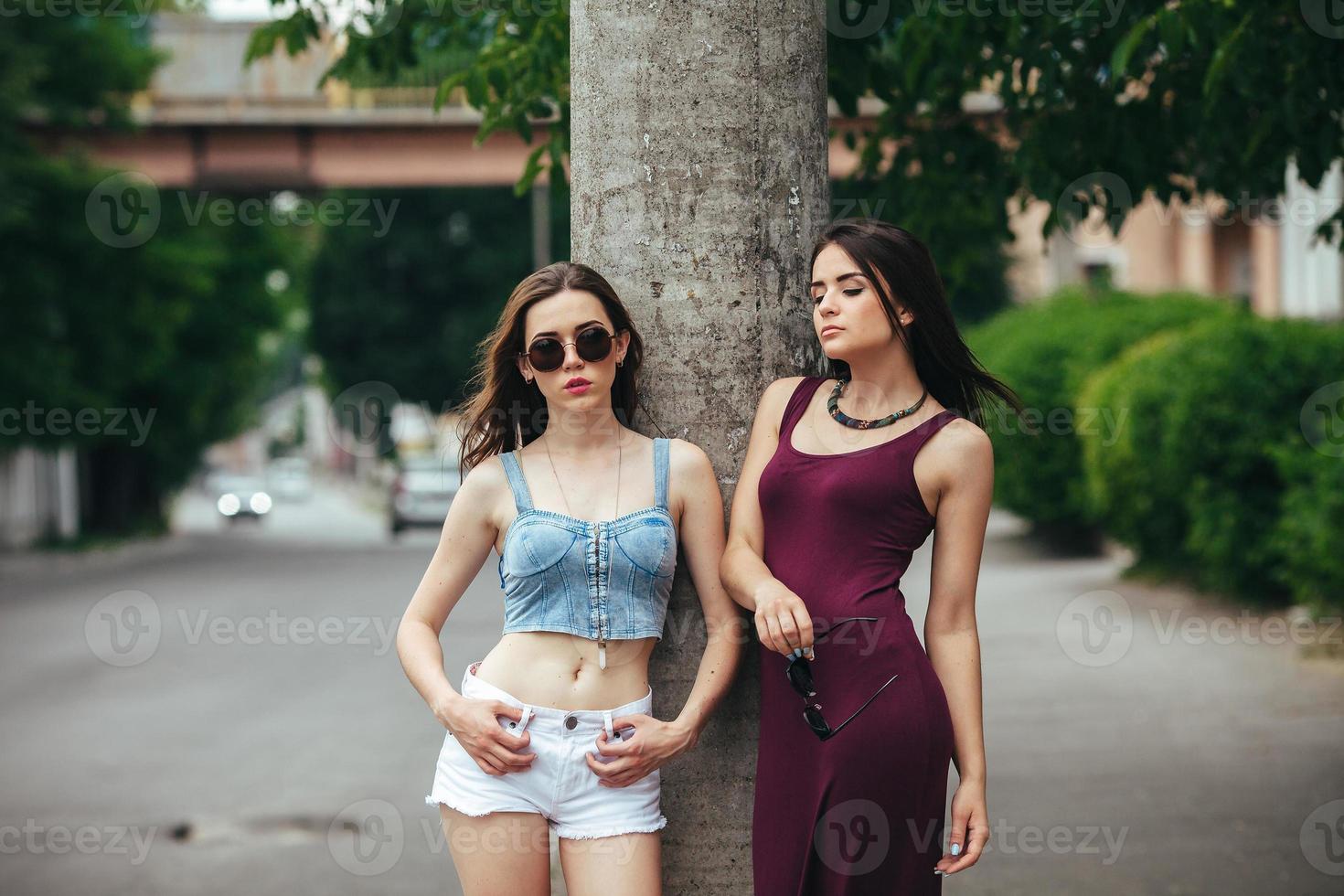 Zwei schöne junge Mädchen posieren in der Stadt foto