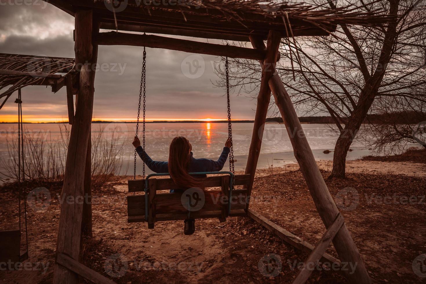 frau, die zeit genießt, sich am schönen see bei sonnenaufgang zu entspannen. foto