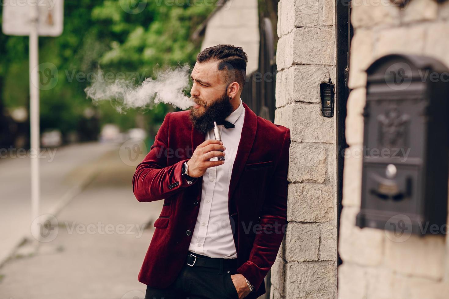 bärtiger Mann mit E-Zigarette foto
