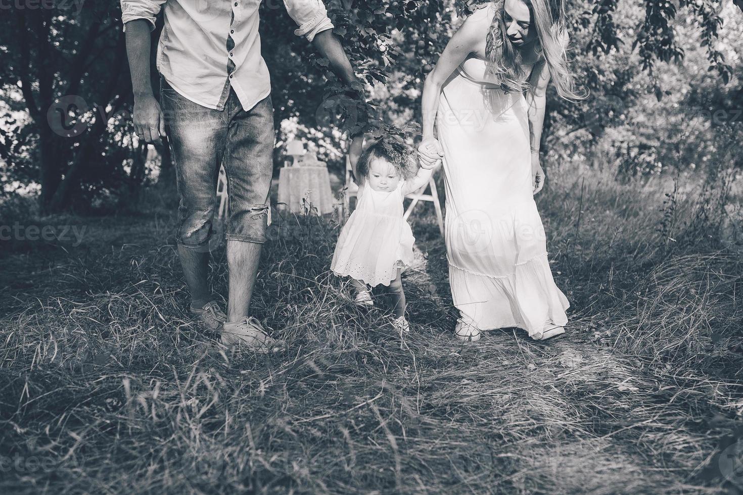 junge familie, die im garten spaziert foto