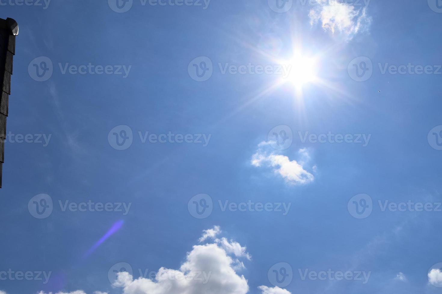 schöne aussicht auf sonnenstrahlen mit einigen linseneffekten und wolken am blauen himmel foto