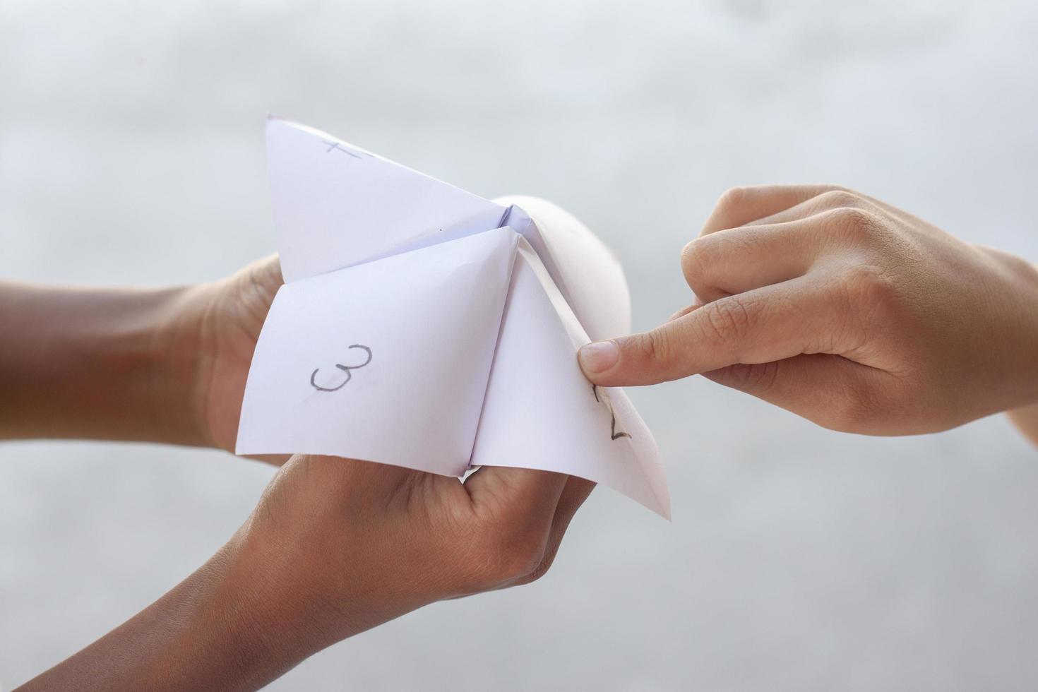 Kinder spielen lustige Wahrsagerspiele aus Papier. foto