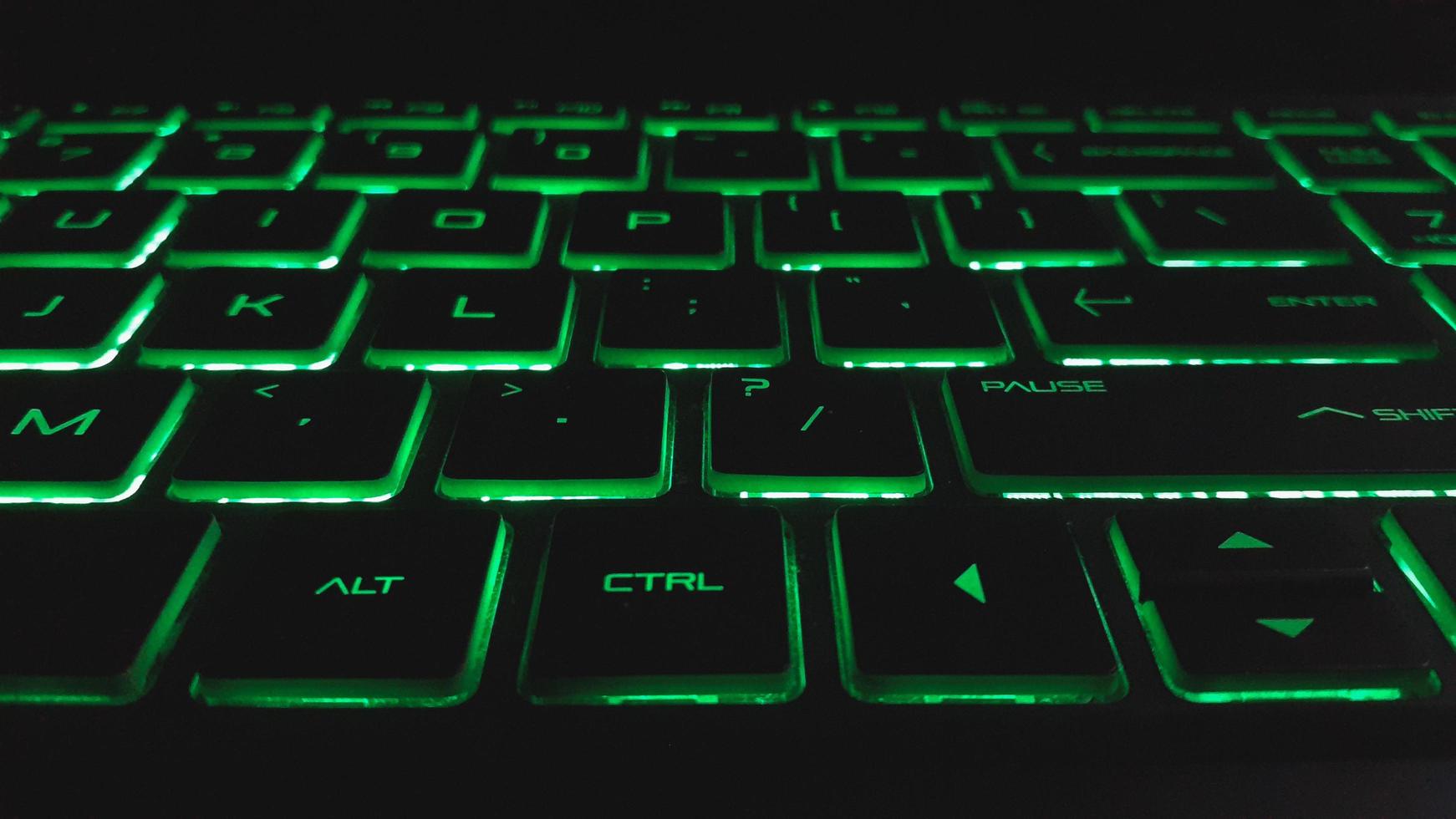 qwerty-Laptoptastatur mit grünem Licht. moderner technologischer hintergrund foto