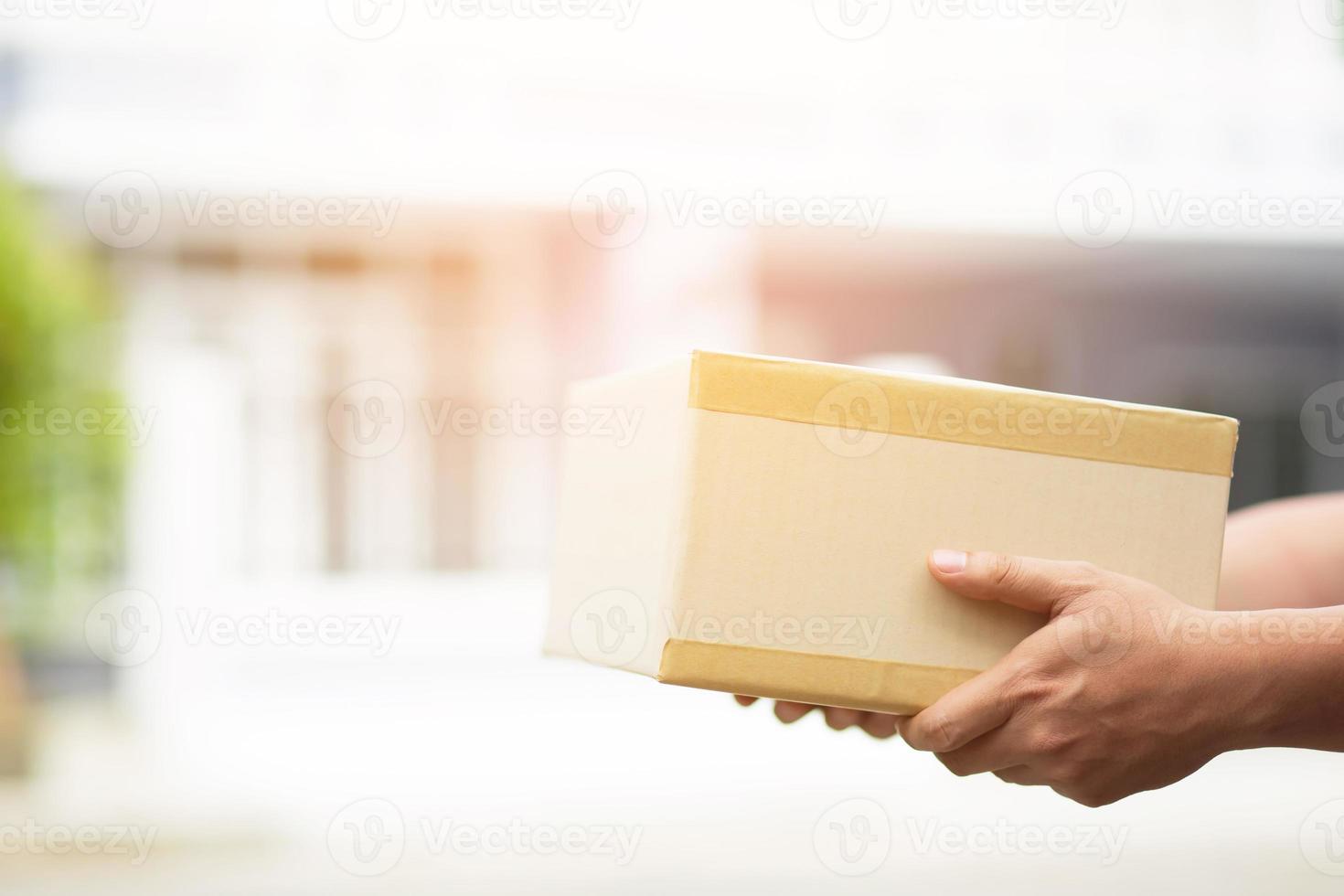 paketzusteller tragen blaue schutzhandschuhe und maske, schützen hygienekeime und bakterien eines pakets durch einen nach hause gesendeten dienst. hand, die sendung hält und einreichungskunde, der eine box annimmt foto