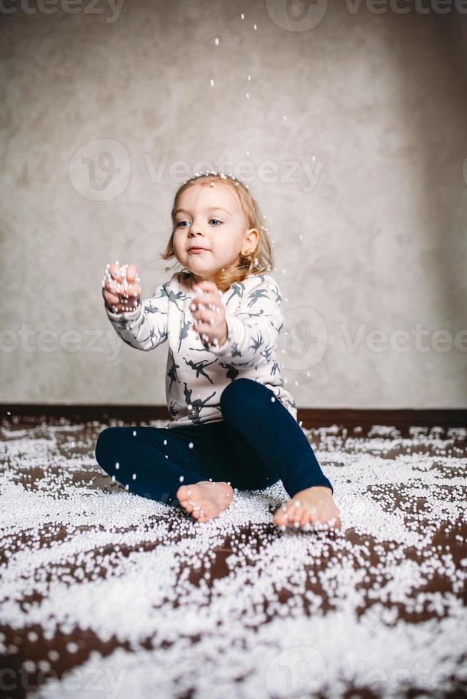 kleines Mädchen spielt mit Schaumstoffbällen foto