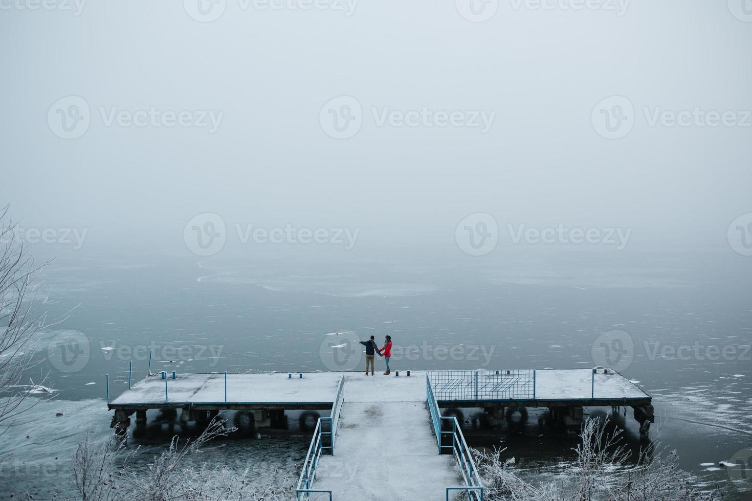 schönes junges Paar, das auf einem Pier steht foto