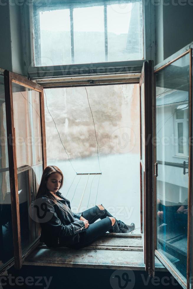 schöne Frau posiert auf einer Fensterbank foto