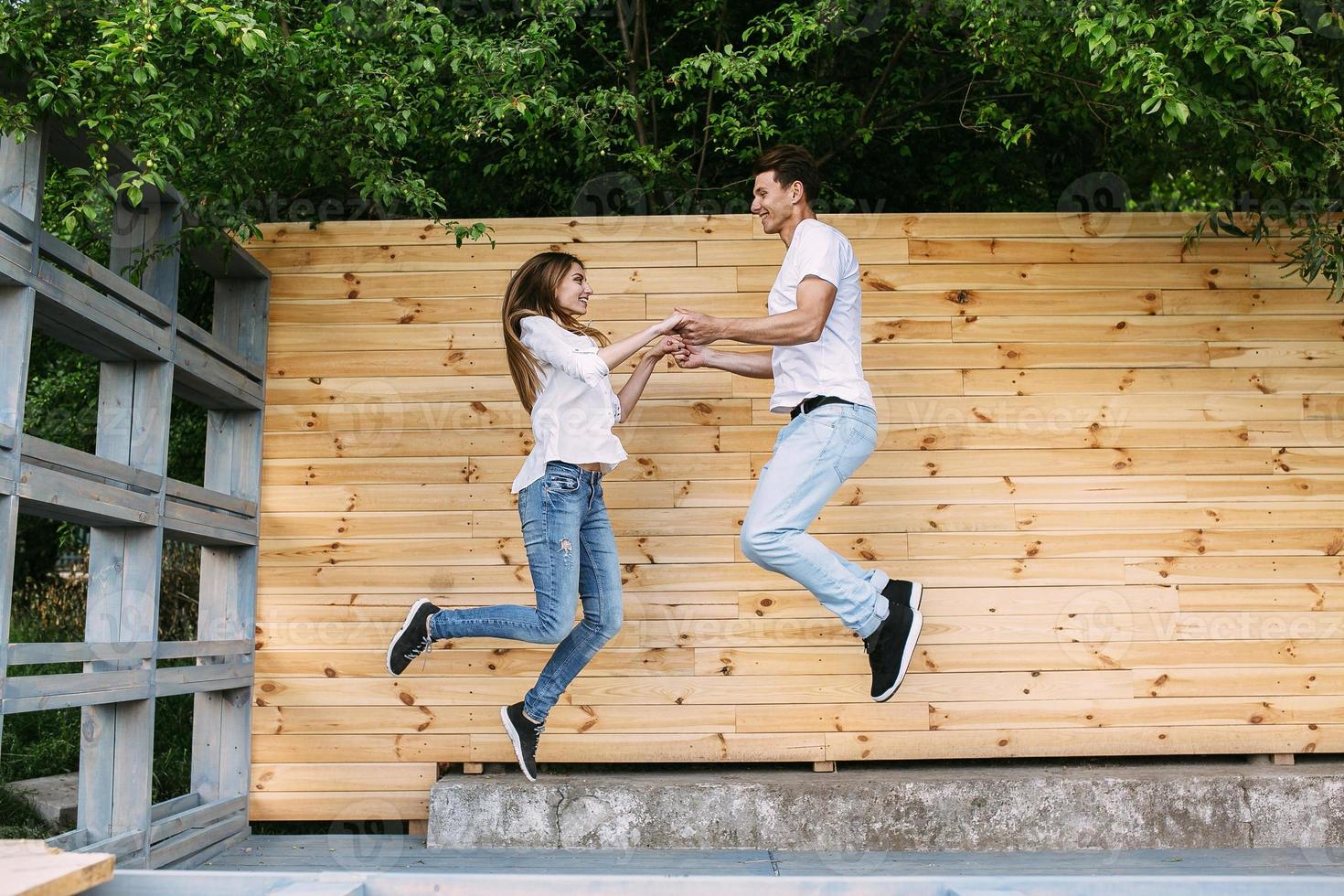 Paar posiert auf einem Hintergrund der Holzwand foto