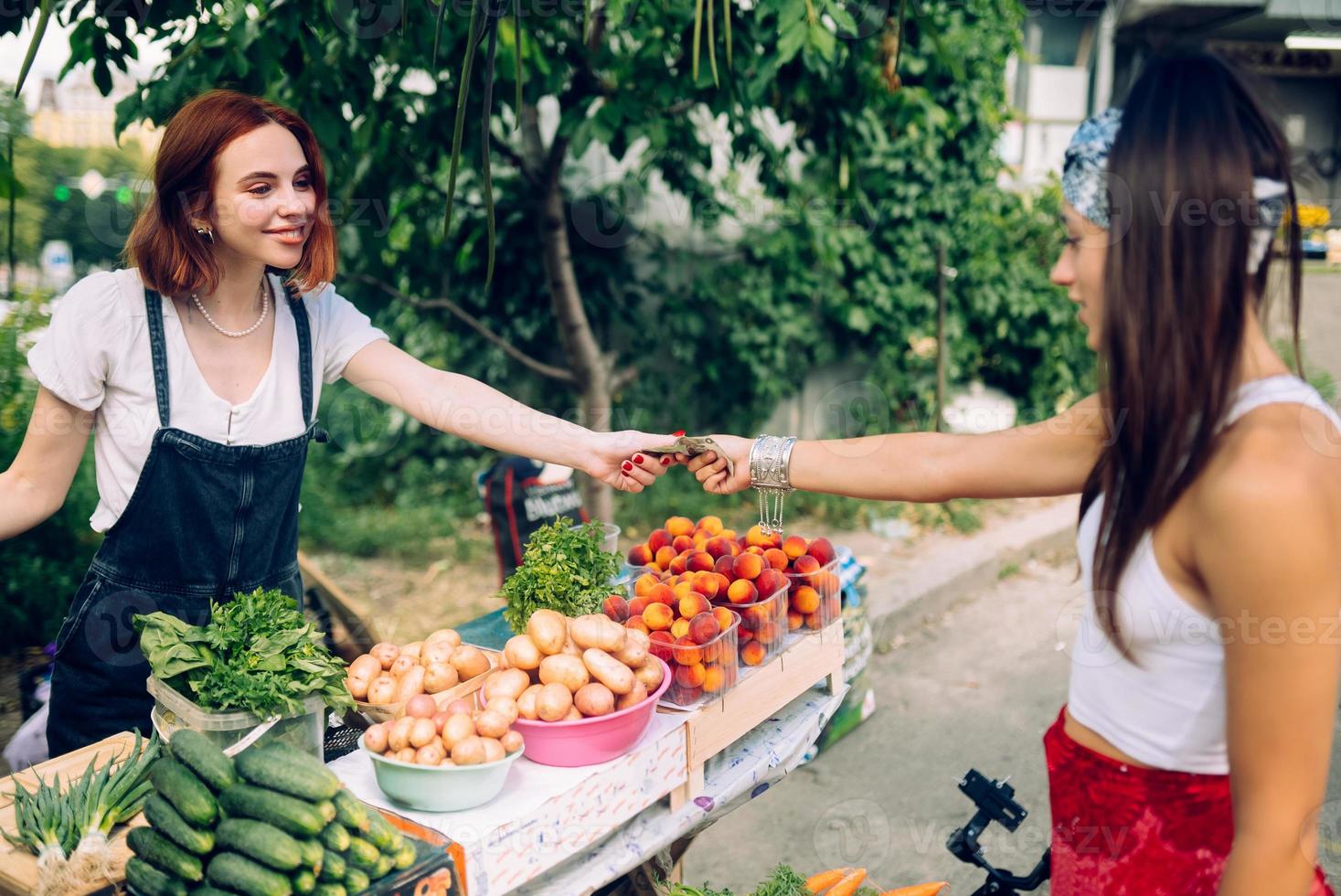 Verkäuferin bietet Bauernmarkt für frisches und biologisches Gemüse an. foto