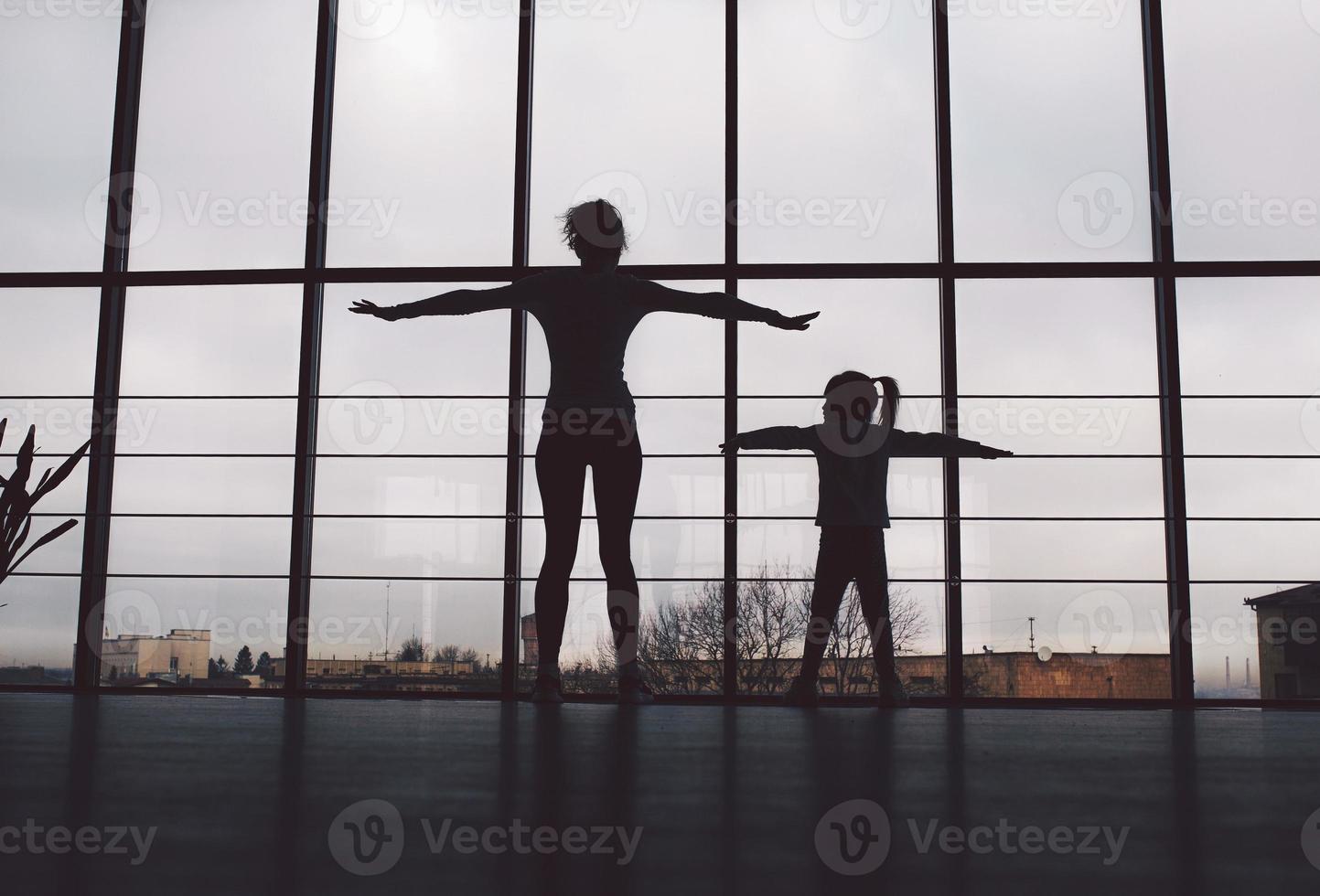 Silhouette von Mutter und Tochter im Fitnessstudio foto