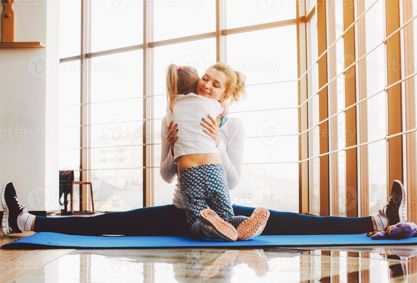 mutter und tochter umarmen sich im fitnessstudio foto