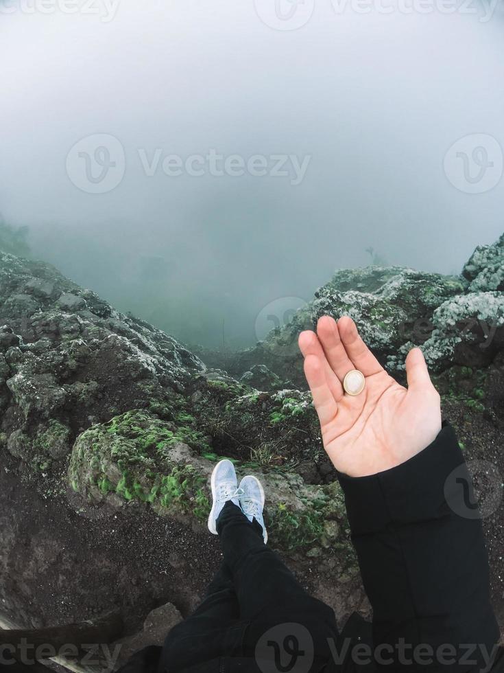 Mann auf Klippe schaut auf den Nebel foto