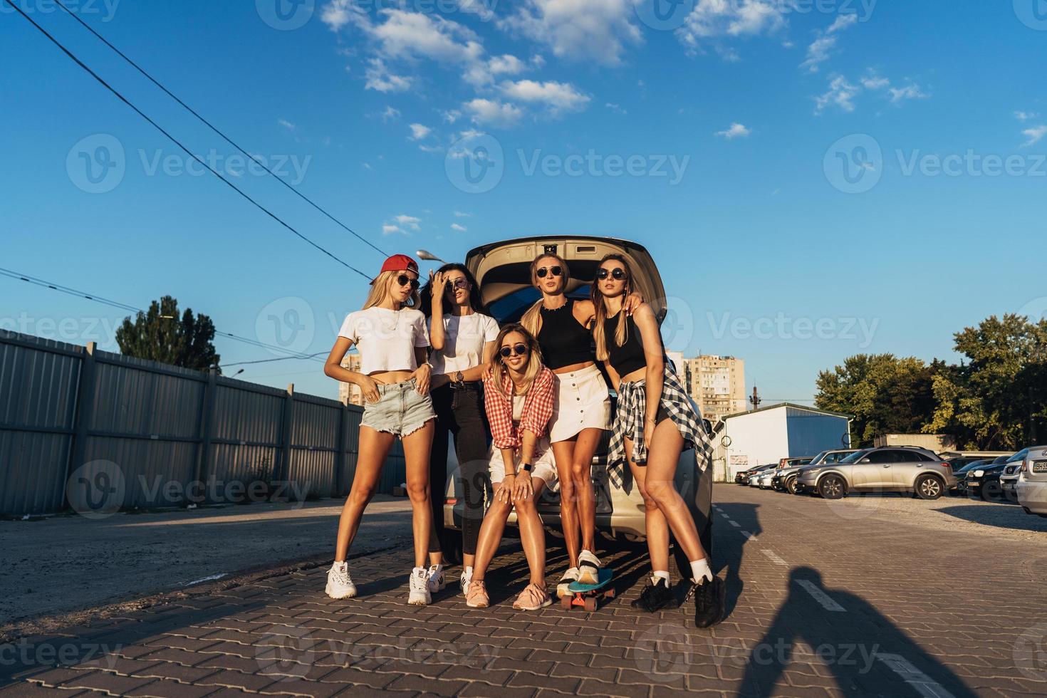 Fünf junge Frauen vergnügen sich auf dem Parkplatz. foto