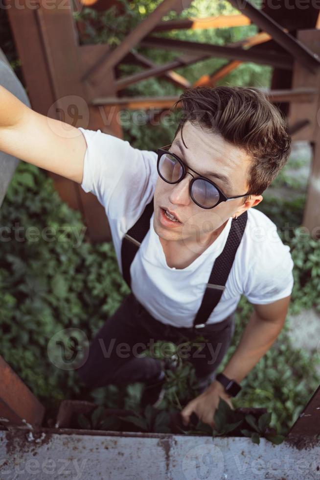 kerl in einem hemd mit hosenträgern zwischen alten metallstrukturen foto