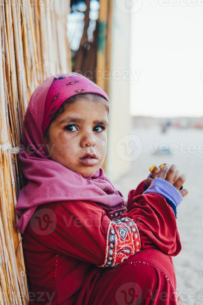 armes, trauriges kleines Mädchen sitzt foto