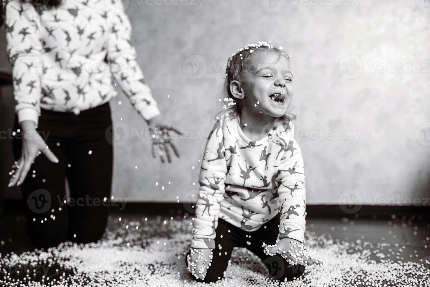 kleines Mädchen spielt mit Schaumstoffbällen foto