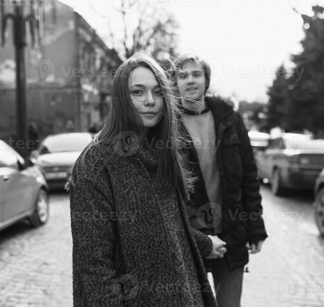 kerl und das mädchen gehen auf einer stadtstraße foto