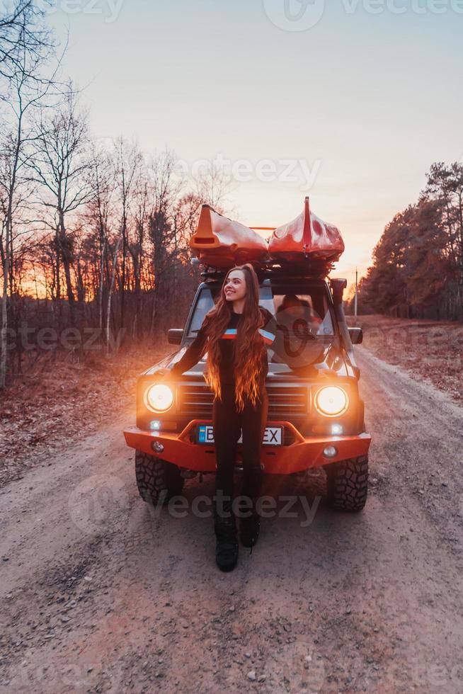 Frau steht vor 4x4-Geländewagen. foto