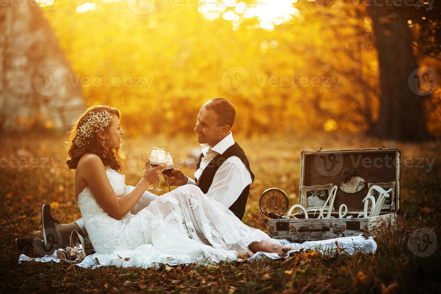 schönes Hochzeitspaar bei einem Picknick unter Baum foto