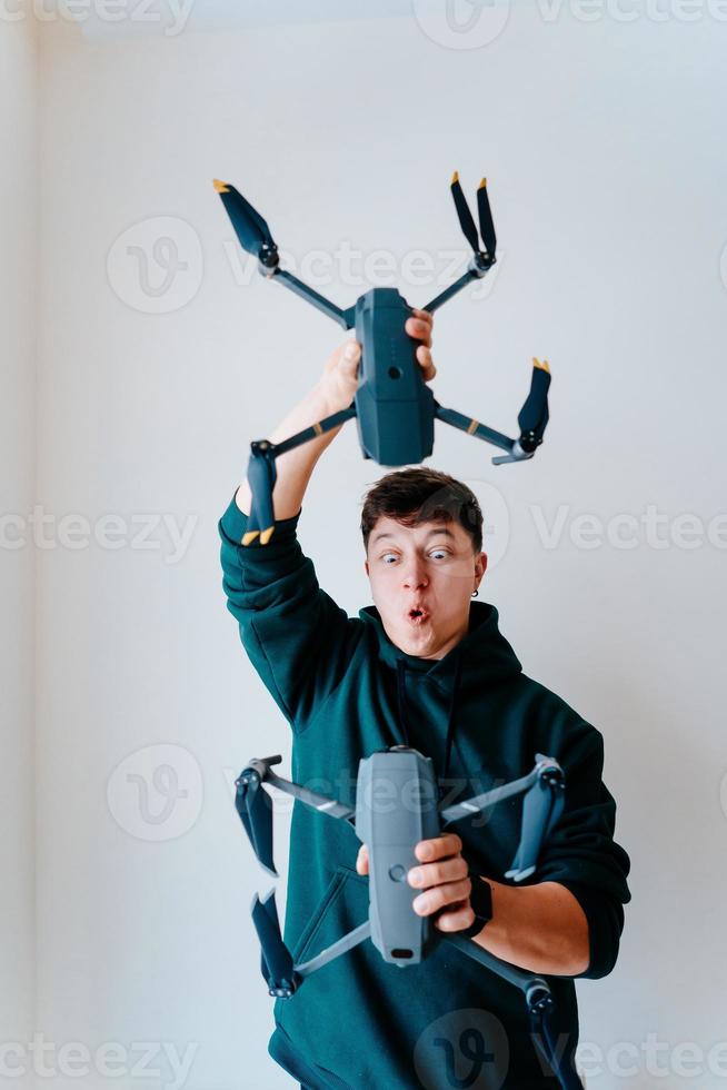 Typ hält zwei Quadrocopter gegen eine Wand foto