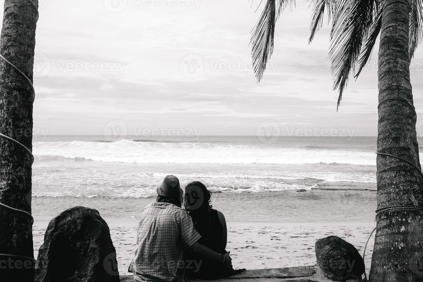 Paar sitzt unter Palmen foto