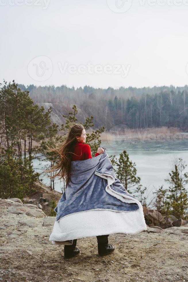 junges schönes mädchen, das auf einem hintergrund des sees aufwirft foto